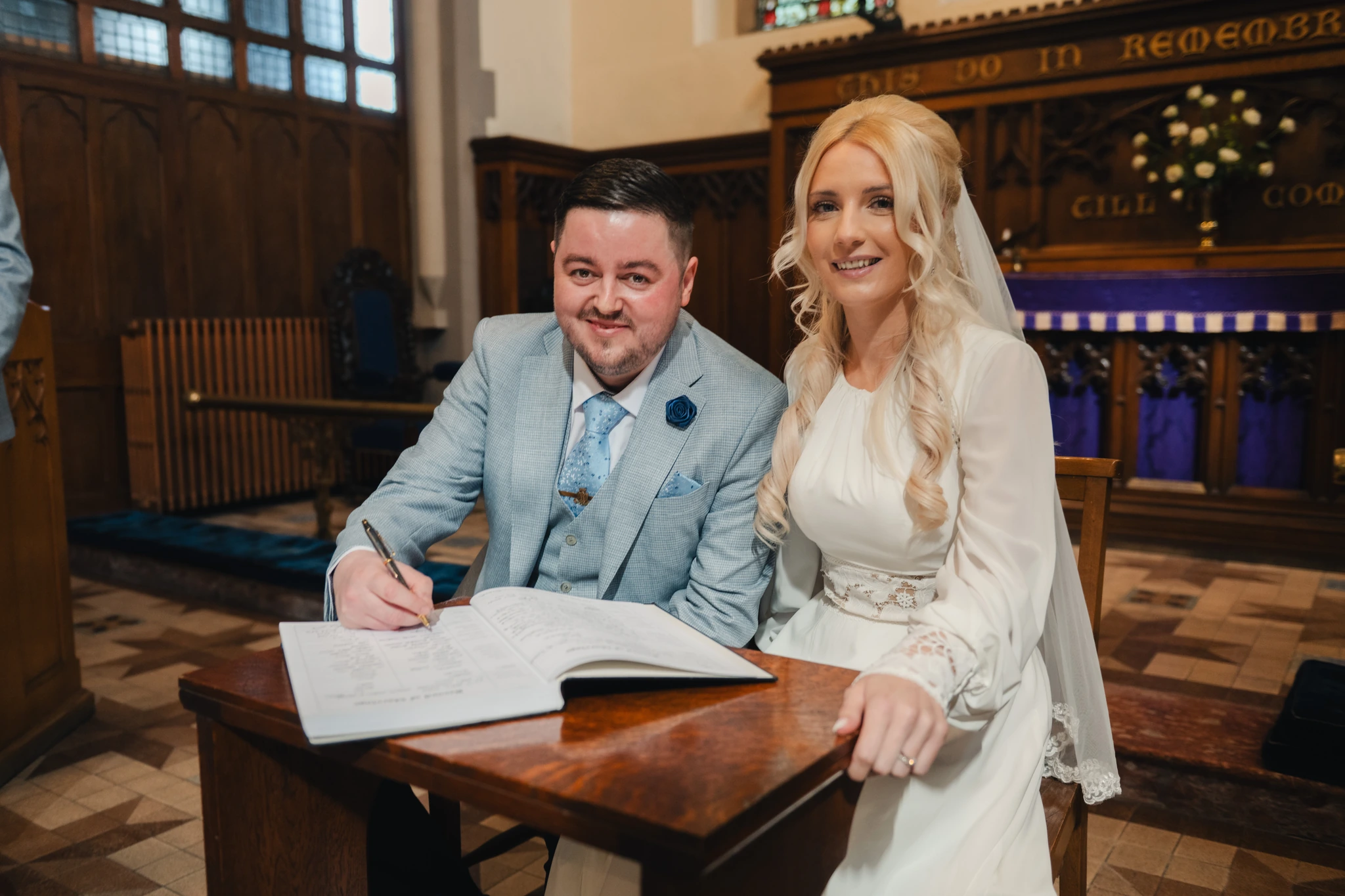a bride and groom signing their wedding vows in a church