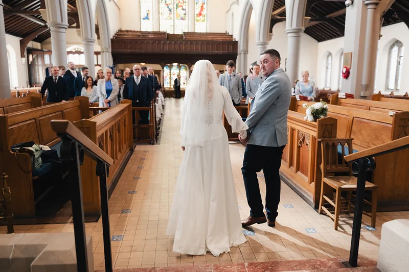 a bride and groom walk down the aisle of a church