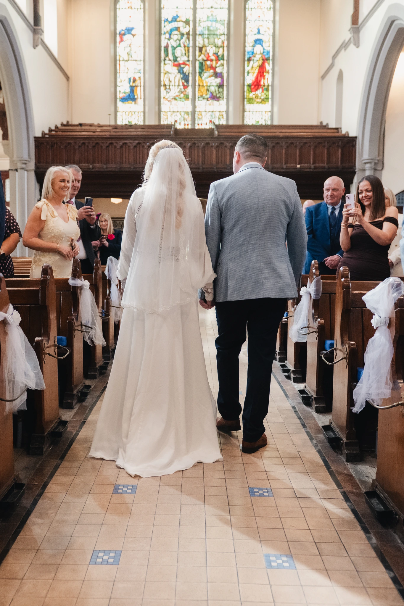 a bride and groom walk down the aisle of a church