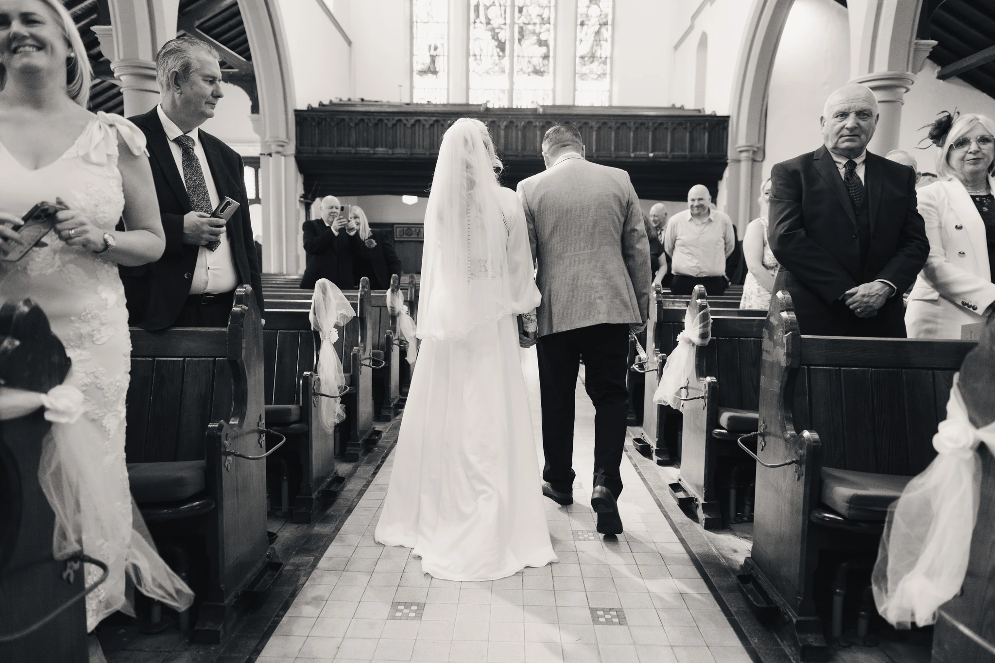 a bride and groom walk down the aisle of a church