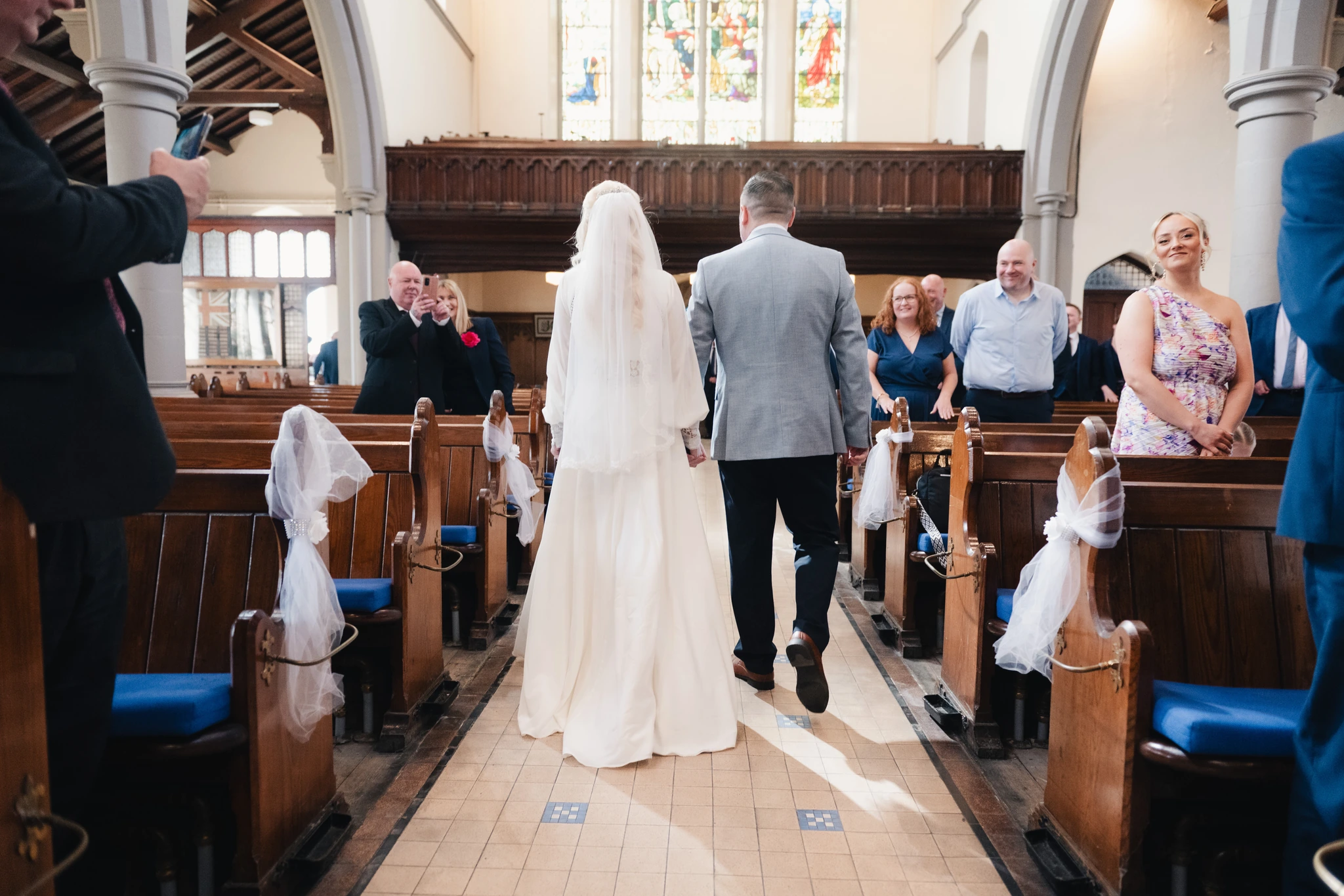 a bride and groom walk down the aisle of a church