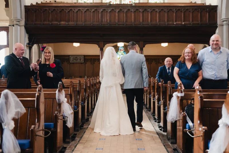 a bride and groom walk down the aisle of a church