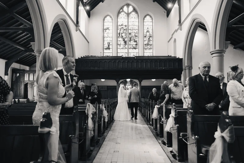 a bride walks down the aisle of a church