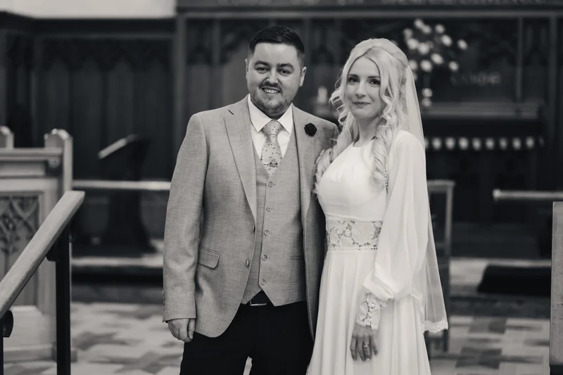 a bride and groom standing in front of a church