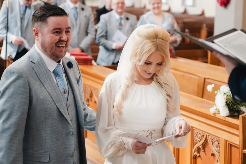 a bride and groom kiss in the church during their wedding ceremony