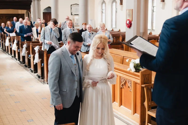 a bride and groom walk down the aisle of a church