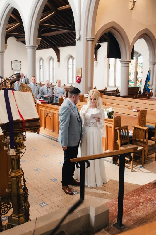 a bride and groom standing in front of a church