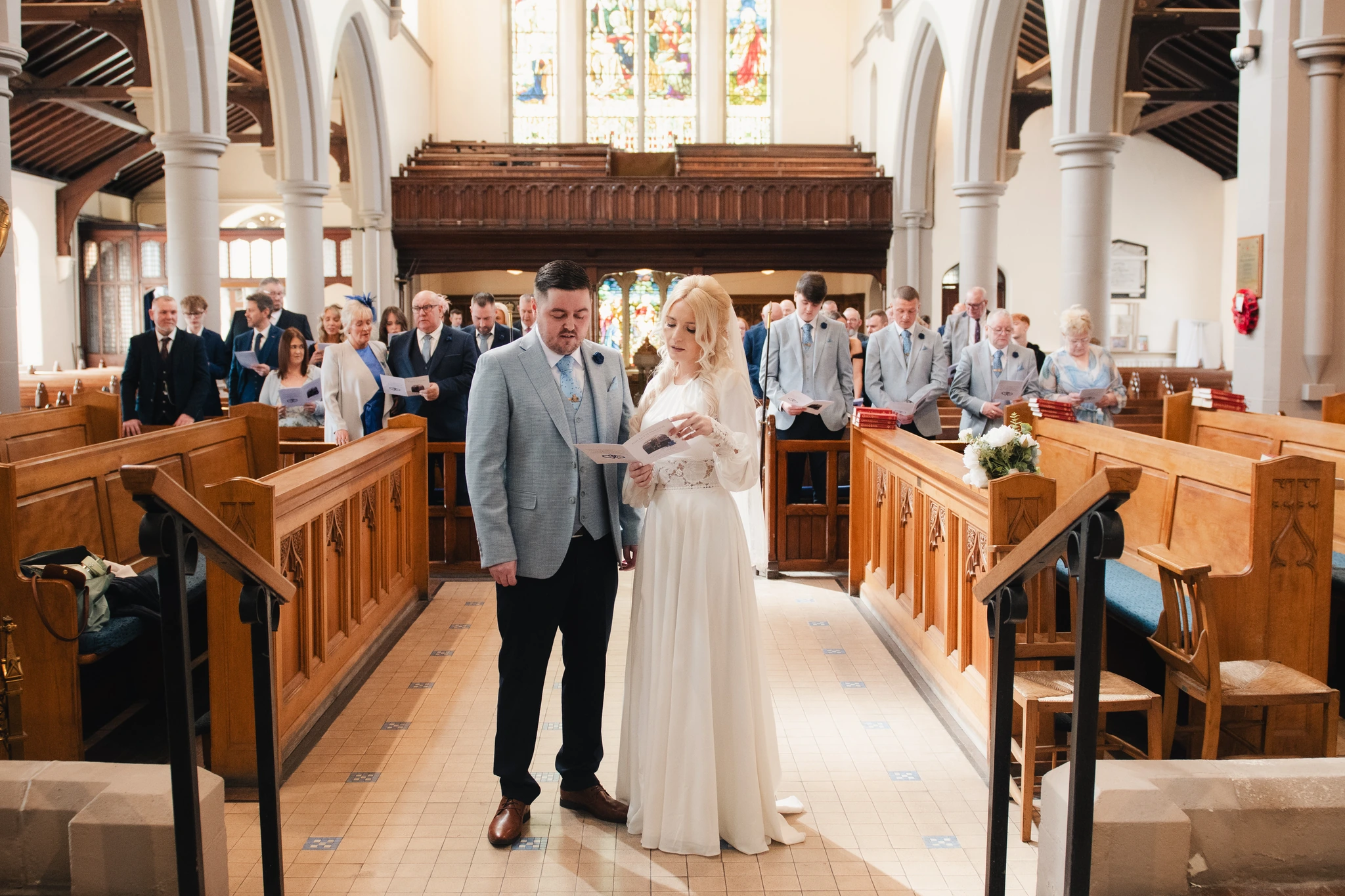 a bride and groom walk down the aisle of a church