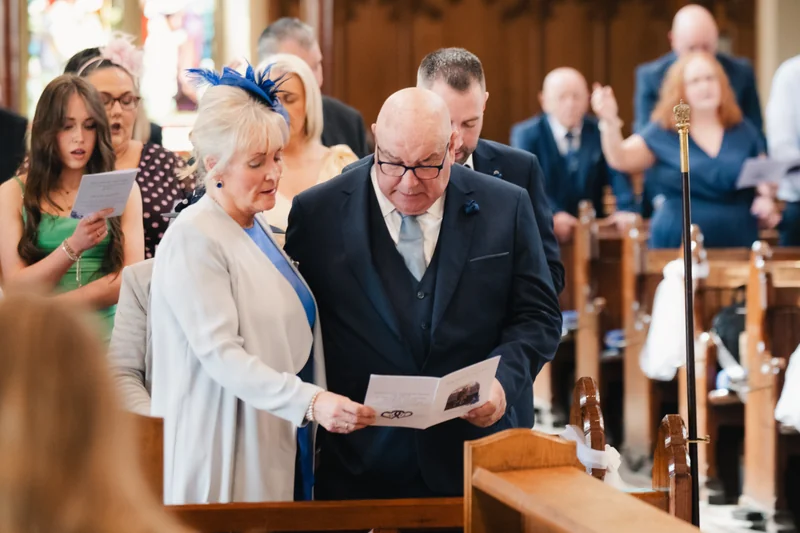 a bride and groom walk down the aisle of a church