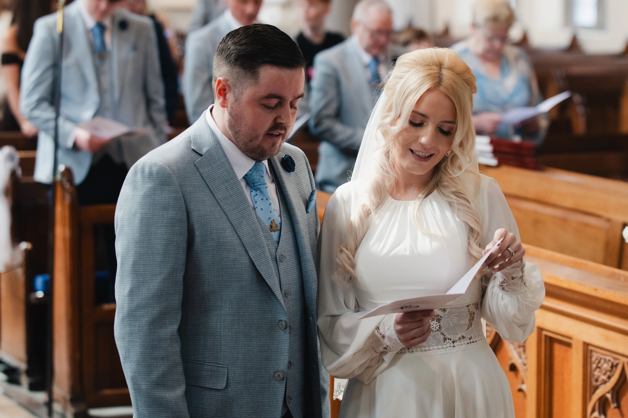 a bride and groom read their wedding vows in a church