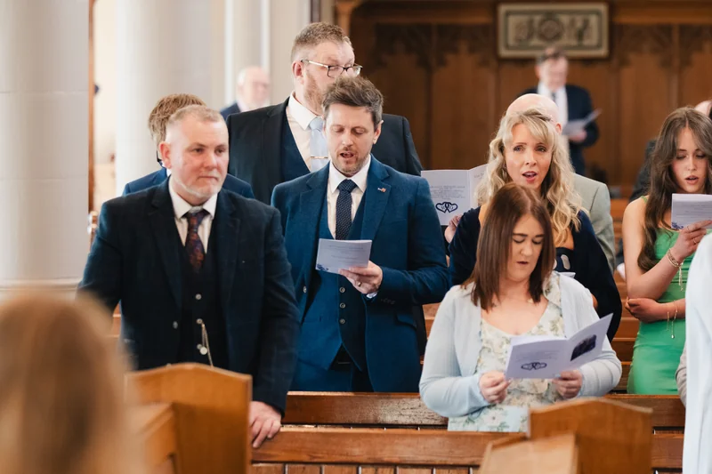 a group of people singing a song in a church