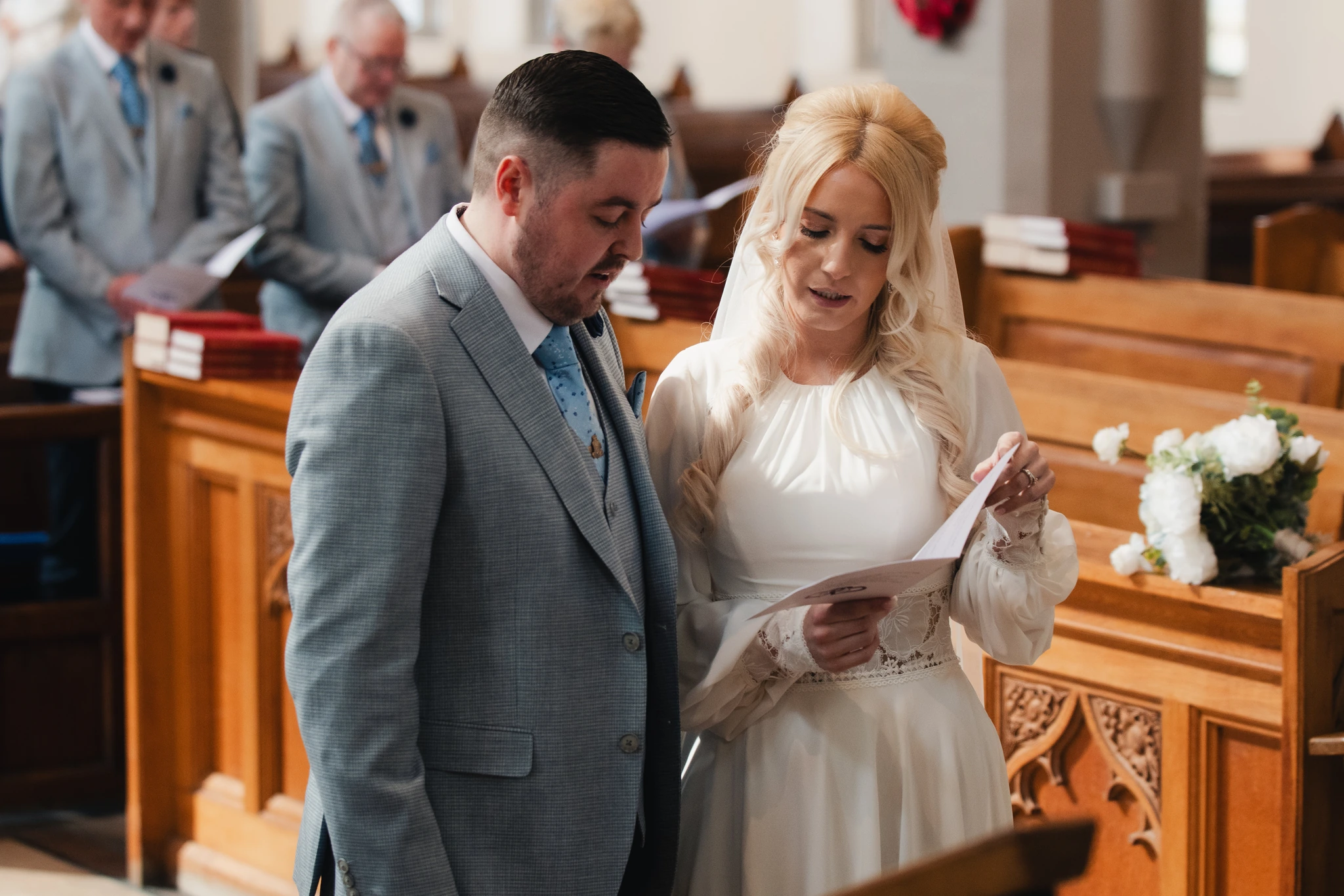 a bride and groom read their wedding vows in a church