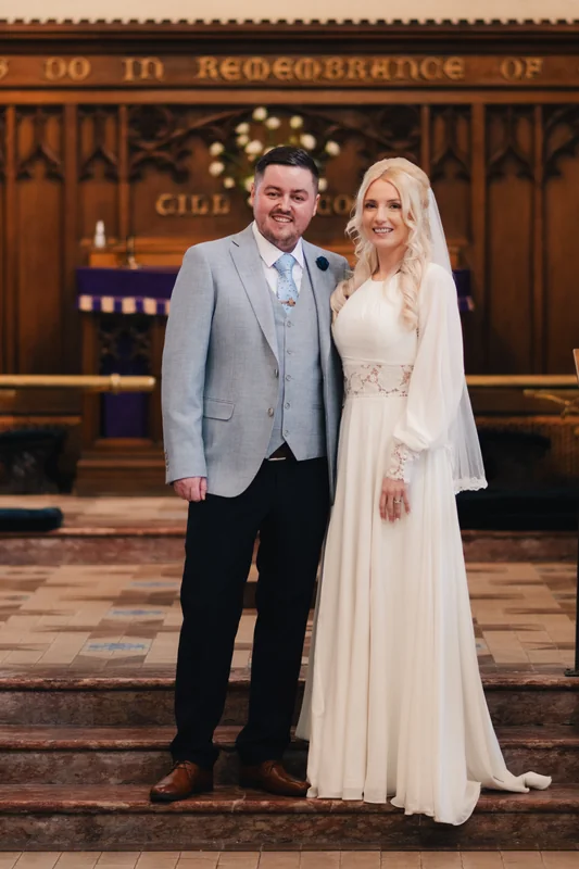 a bride and groom standing on the steps of a church