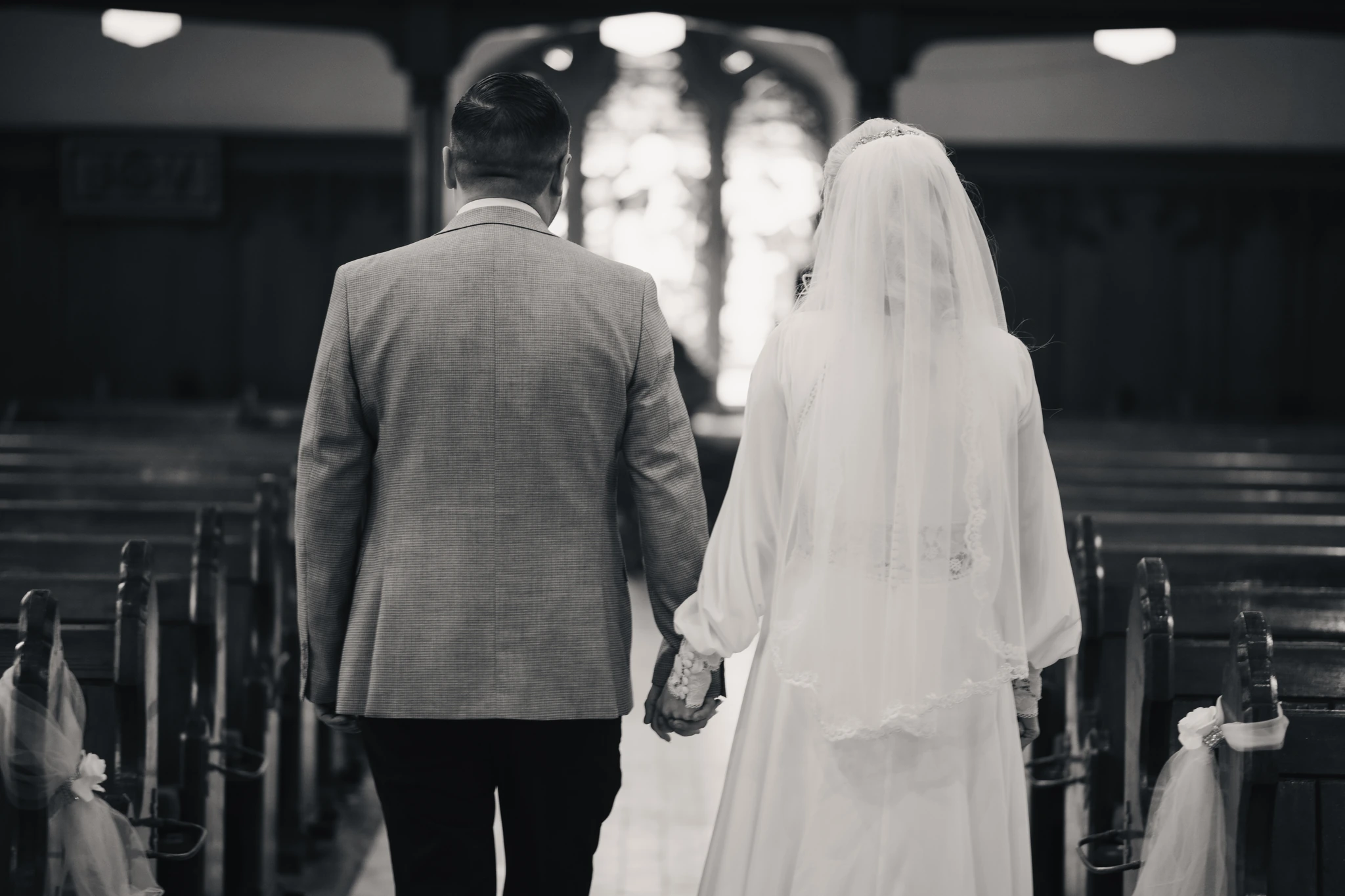 a bride and groom walk down the aisle of a church