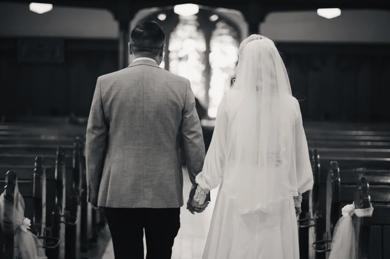 a bride and groom walk down the aisle of a church