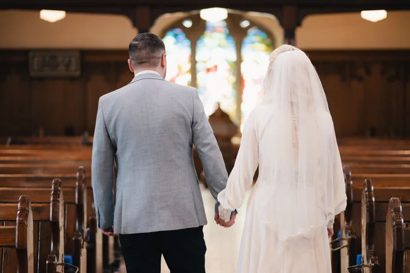 a bride and groom walk down the aisle of a church