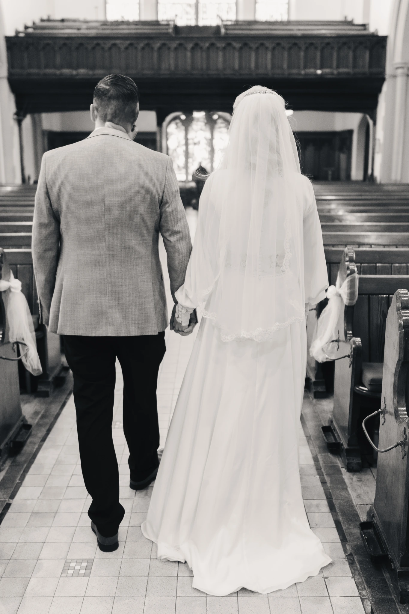 a bride and groom walk down the aisle of a church