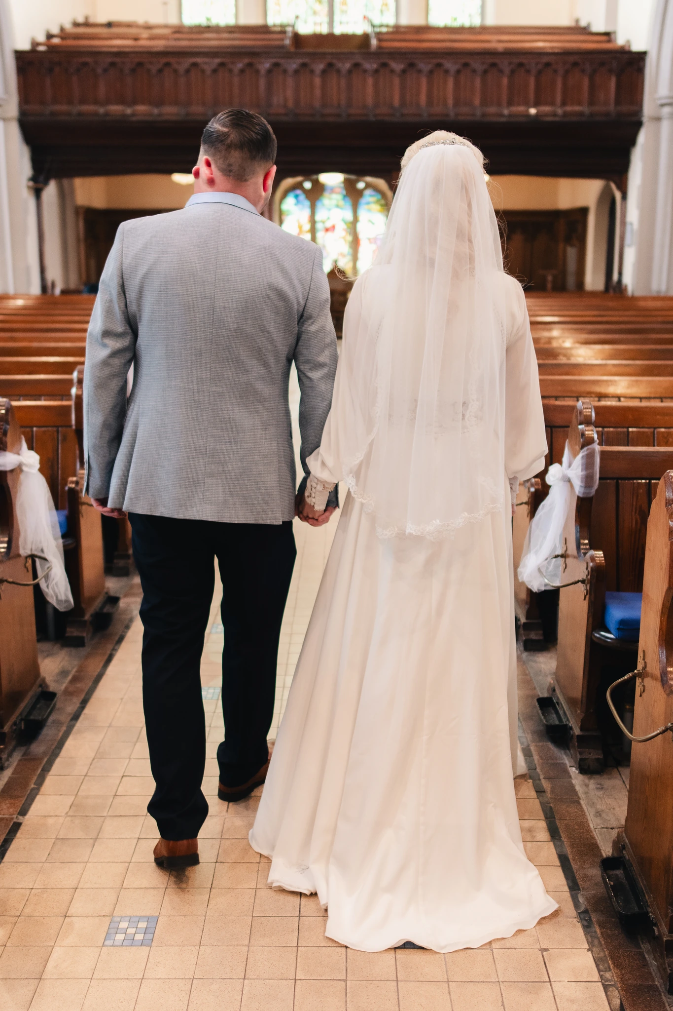 a bride and groom walk down the aisle of a church