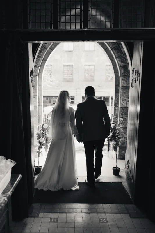 a bride and groom walk down the aisle of a church