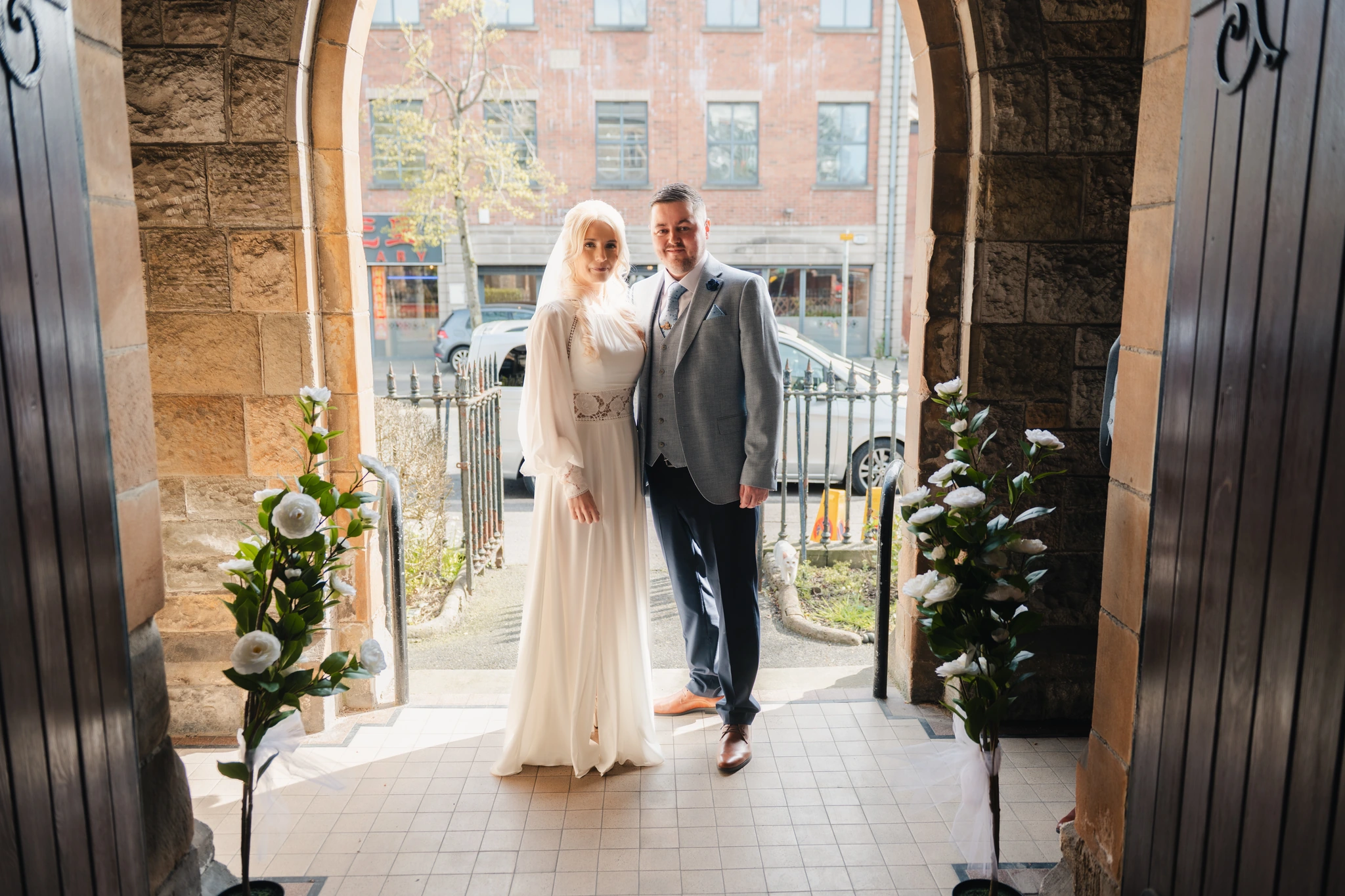 a bride and groom standing in front of a doorway