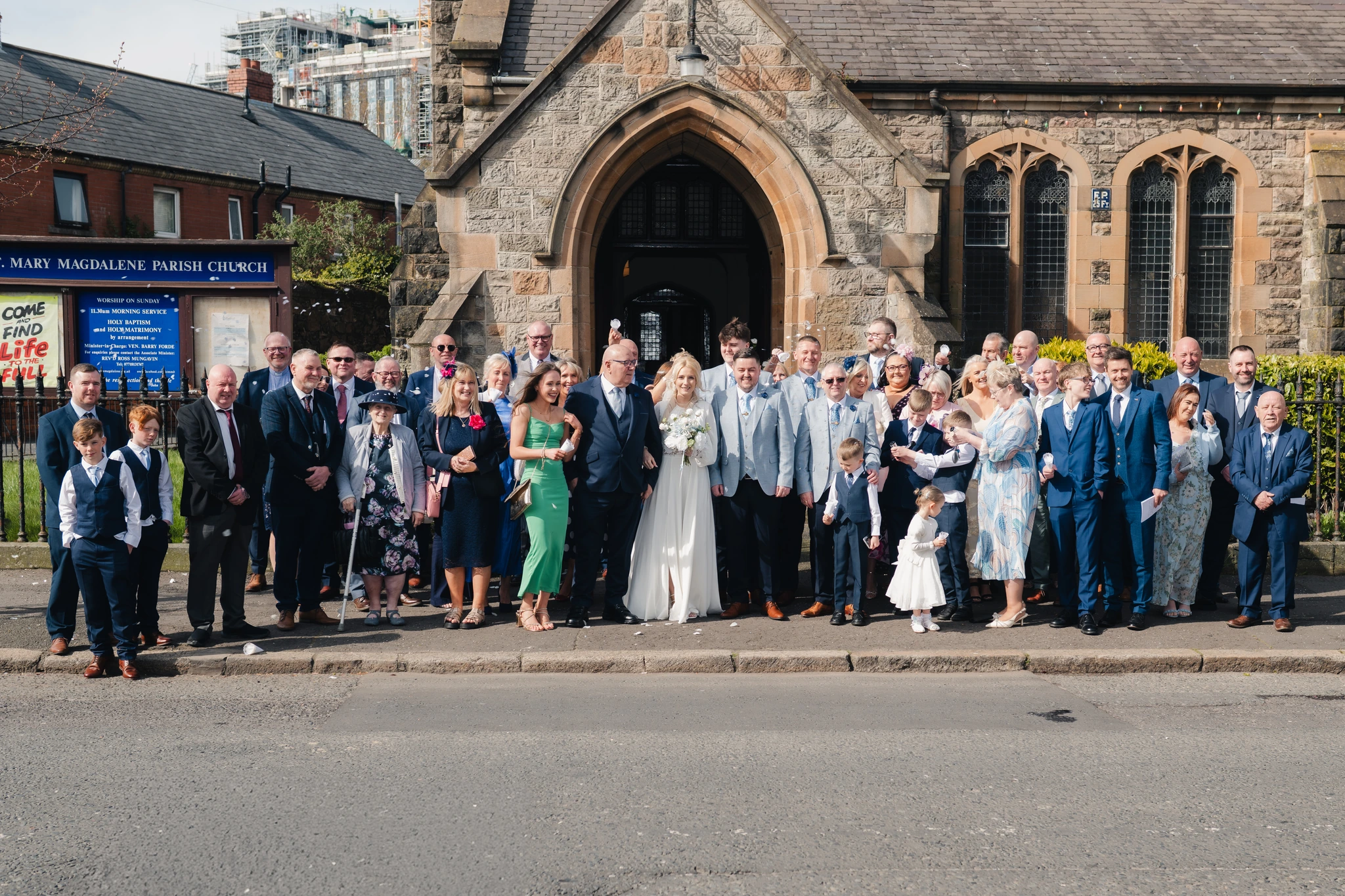 a group of brides and grooms standing in front of a church