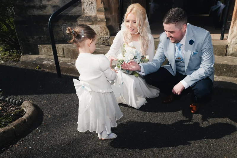 a bride and groom kissing on the steps of a church