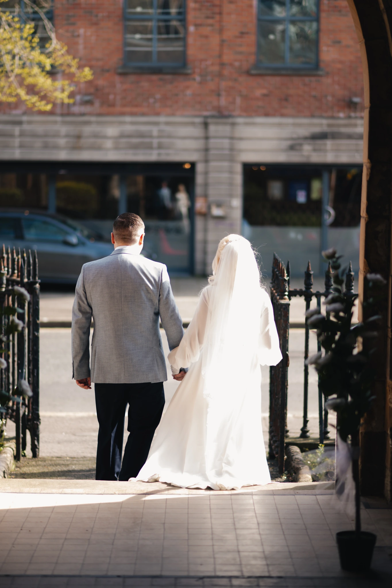 a bride and groom walk down a staircase