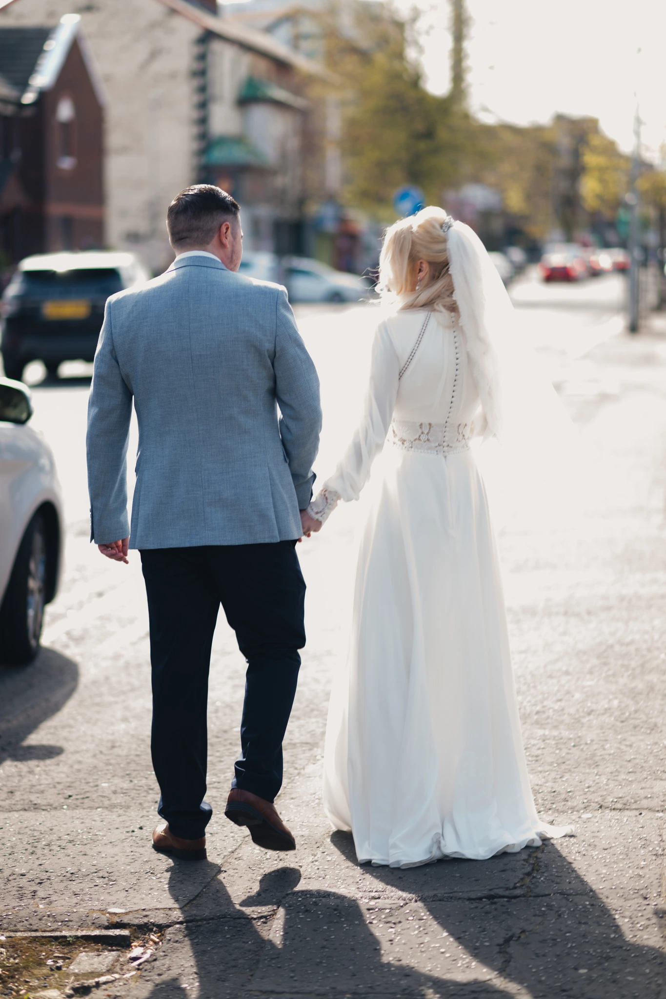a bride and groom walk down a city street