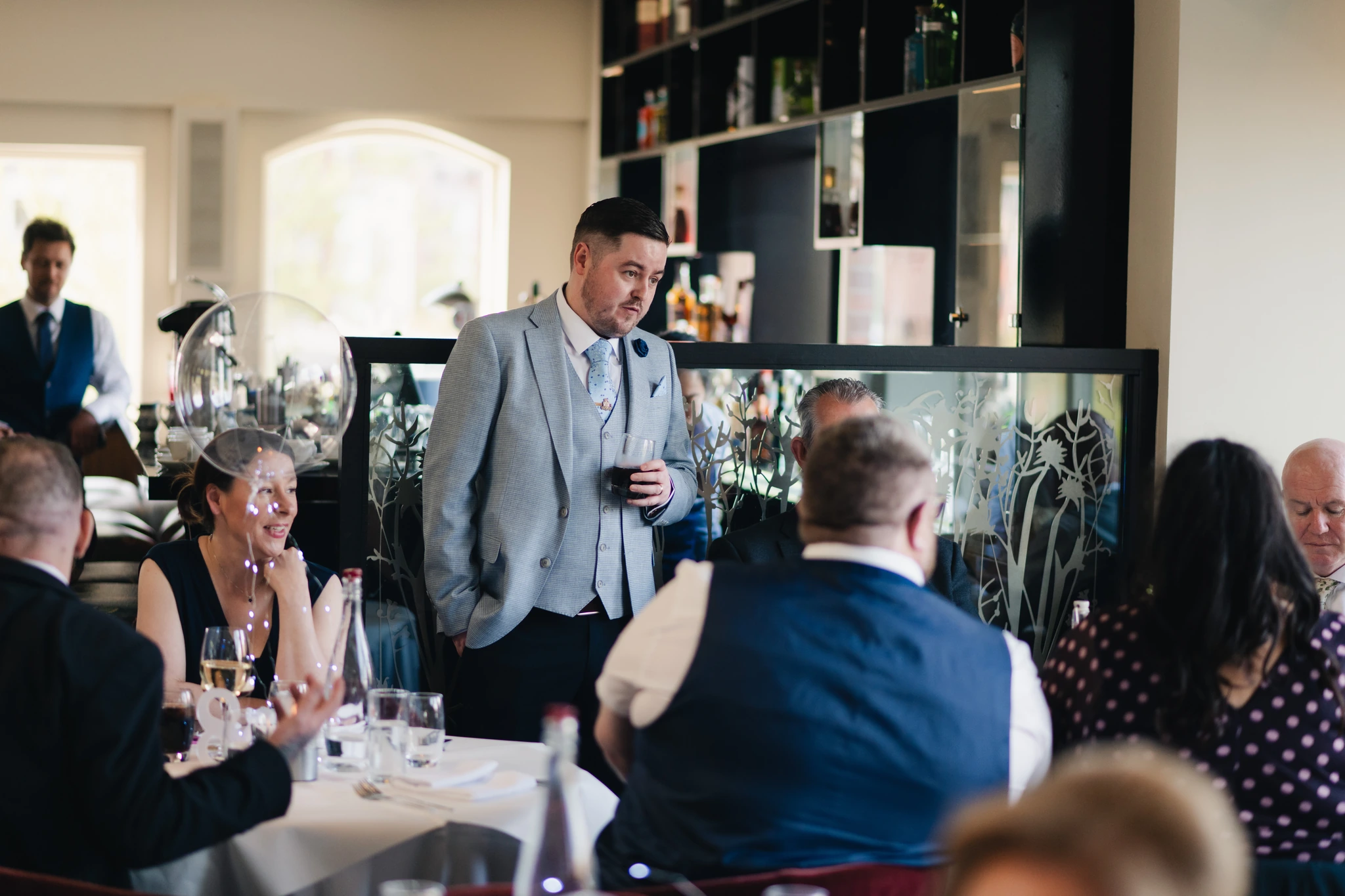 a man speaking to a group of people in a restaurant