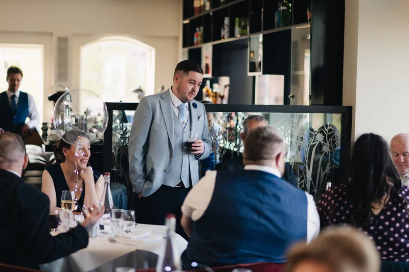 a man speaking to a group of people in a restaurant