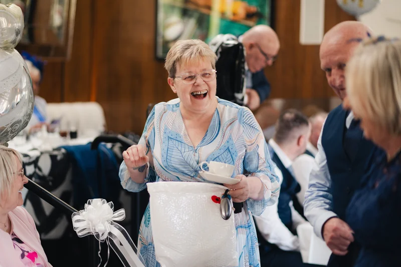 a woman laughs with her friends at a wedding reception