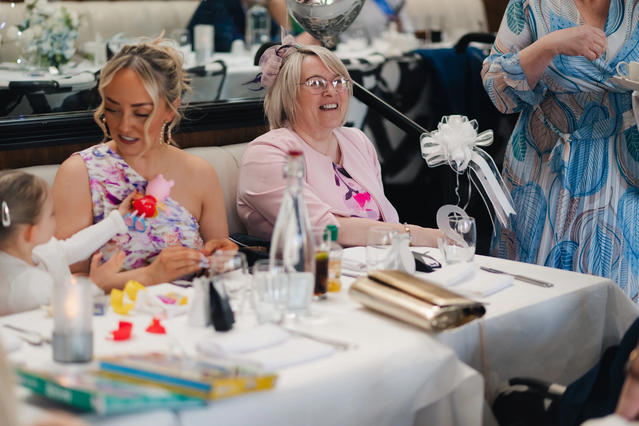 a group of people laughing at a table in a restaurant