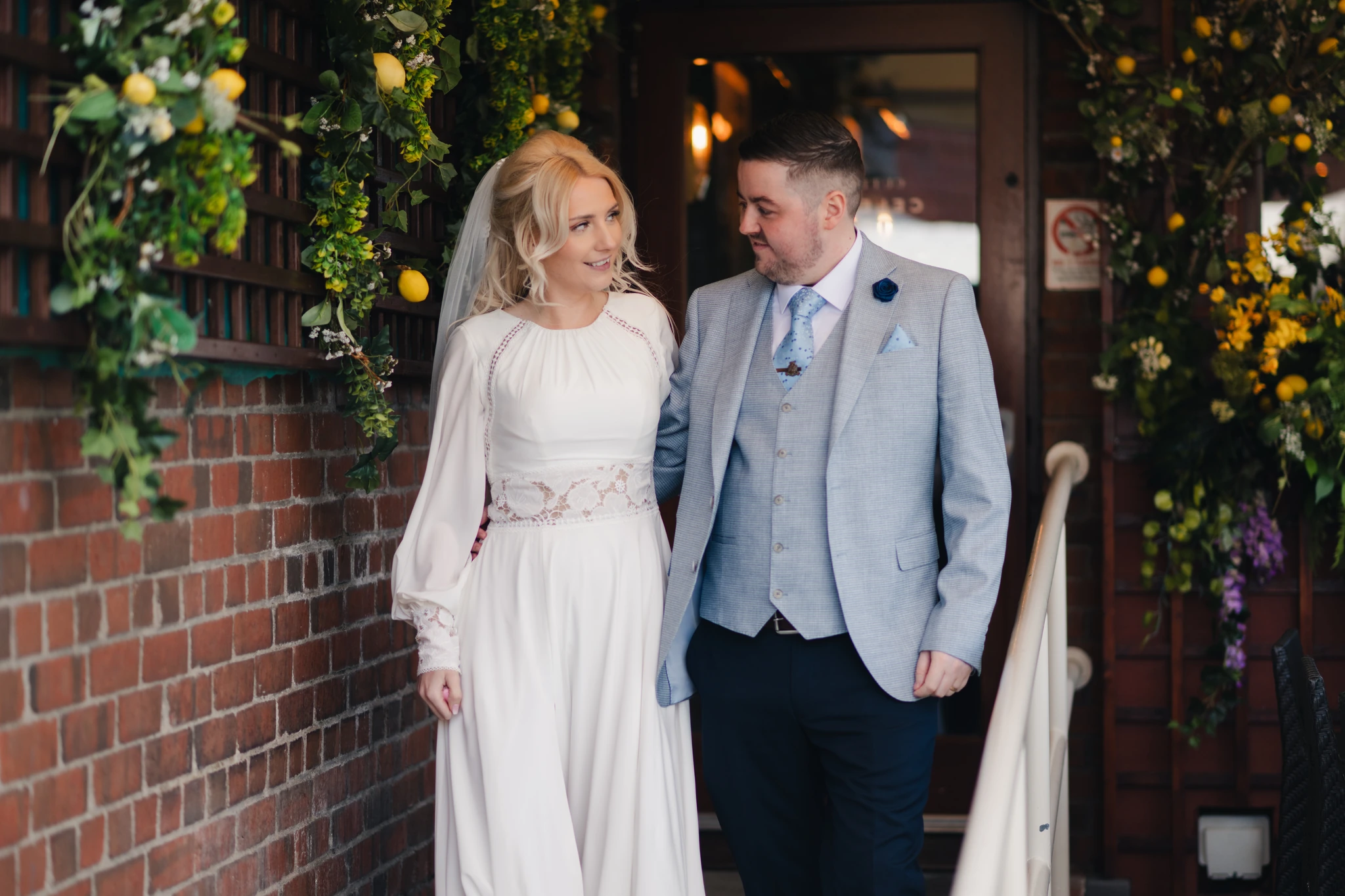 a bride and groom standing in front of a doorway