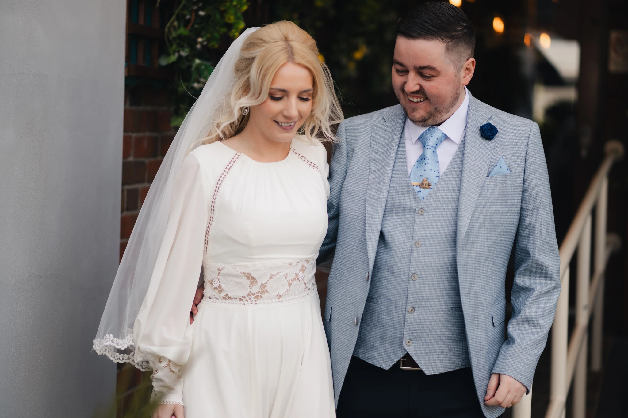 a bride and groom smile at each other as they walk down the aisle