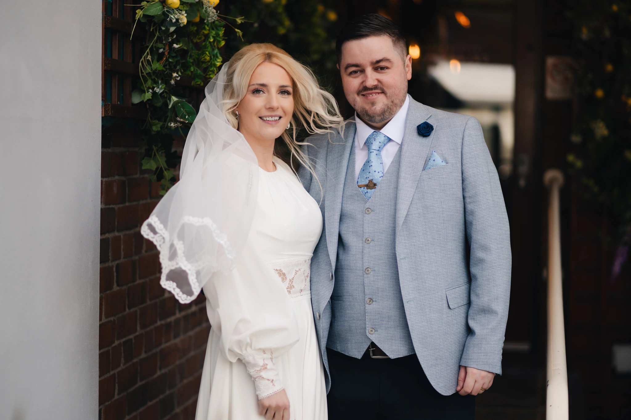 a bride and groom pose for a photo in front of their wedding venue