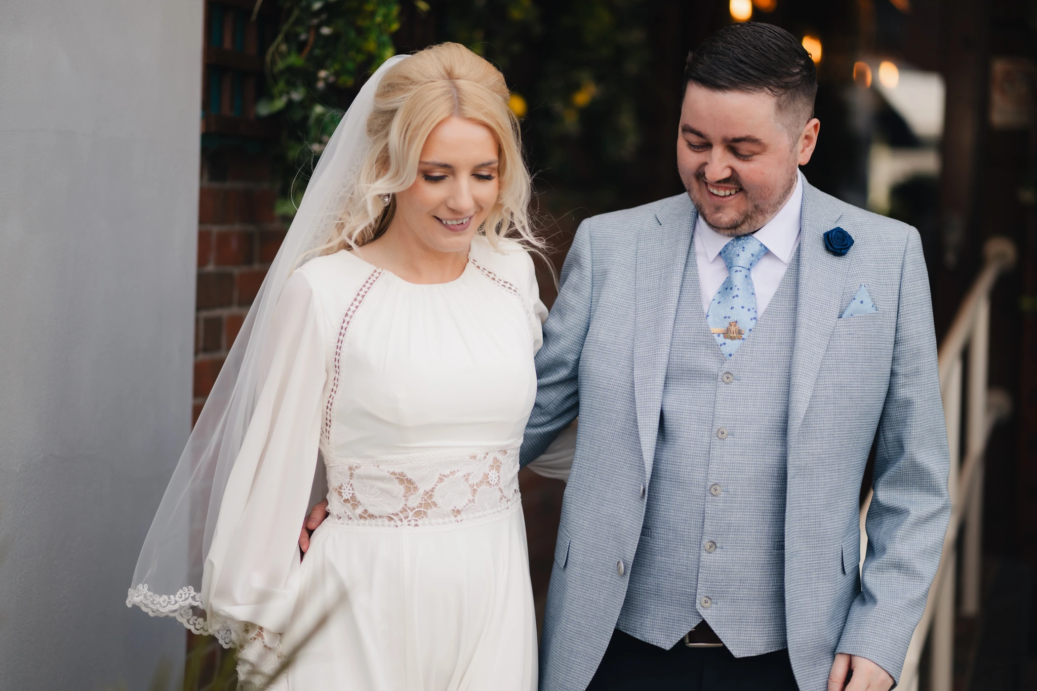 a bride and groom smile at each other as they walk down the aisle