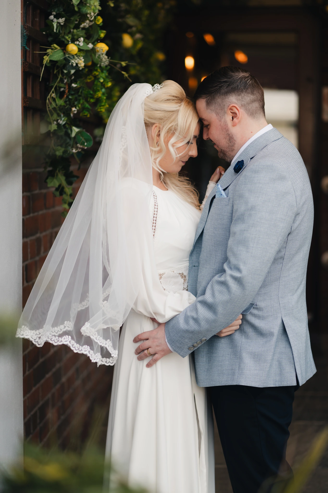 a bride and groom embrace in front of their wedding venue