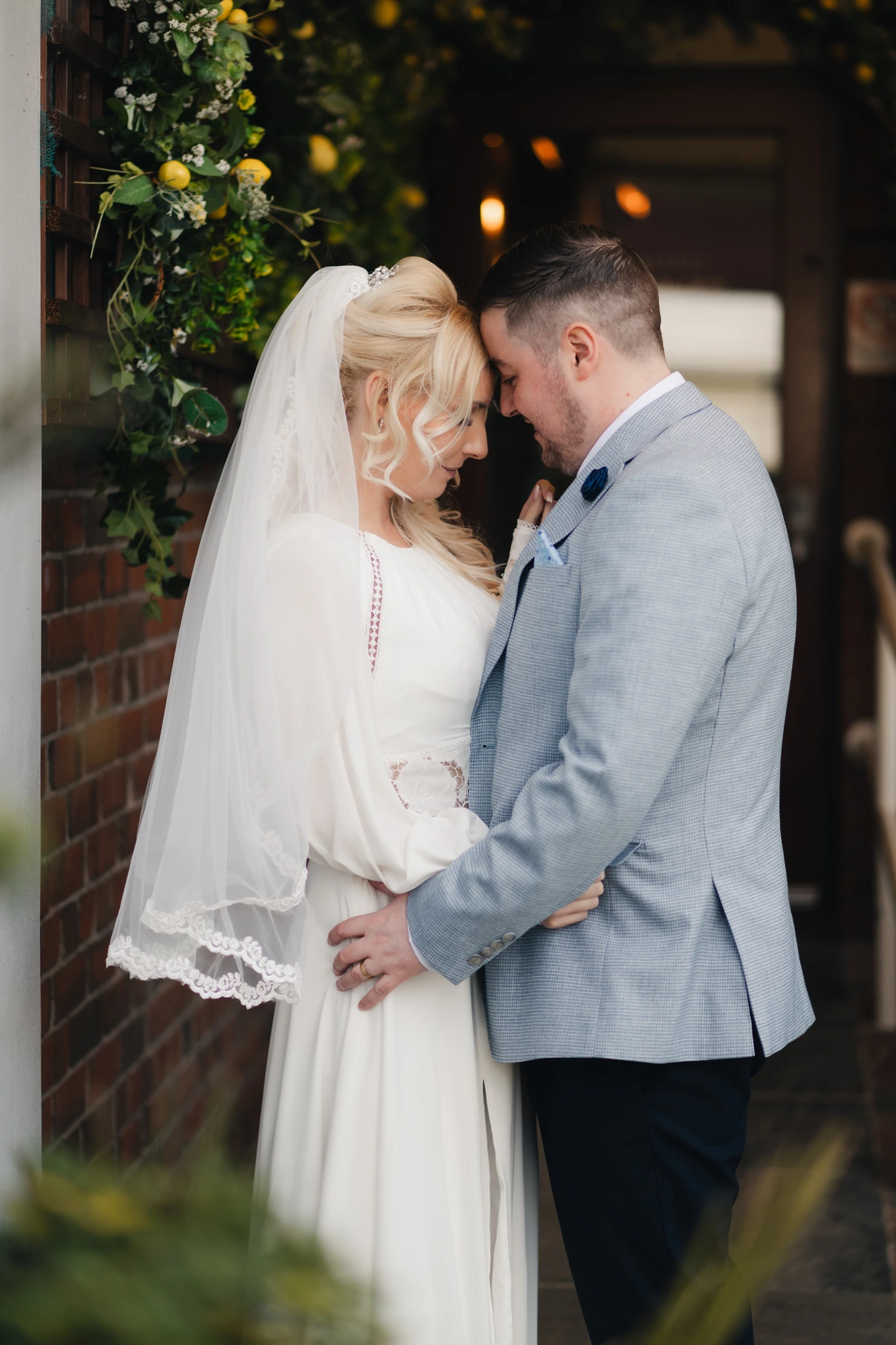 a bride and groom embrace in front of their wedding venue