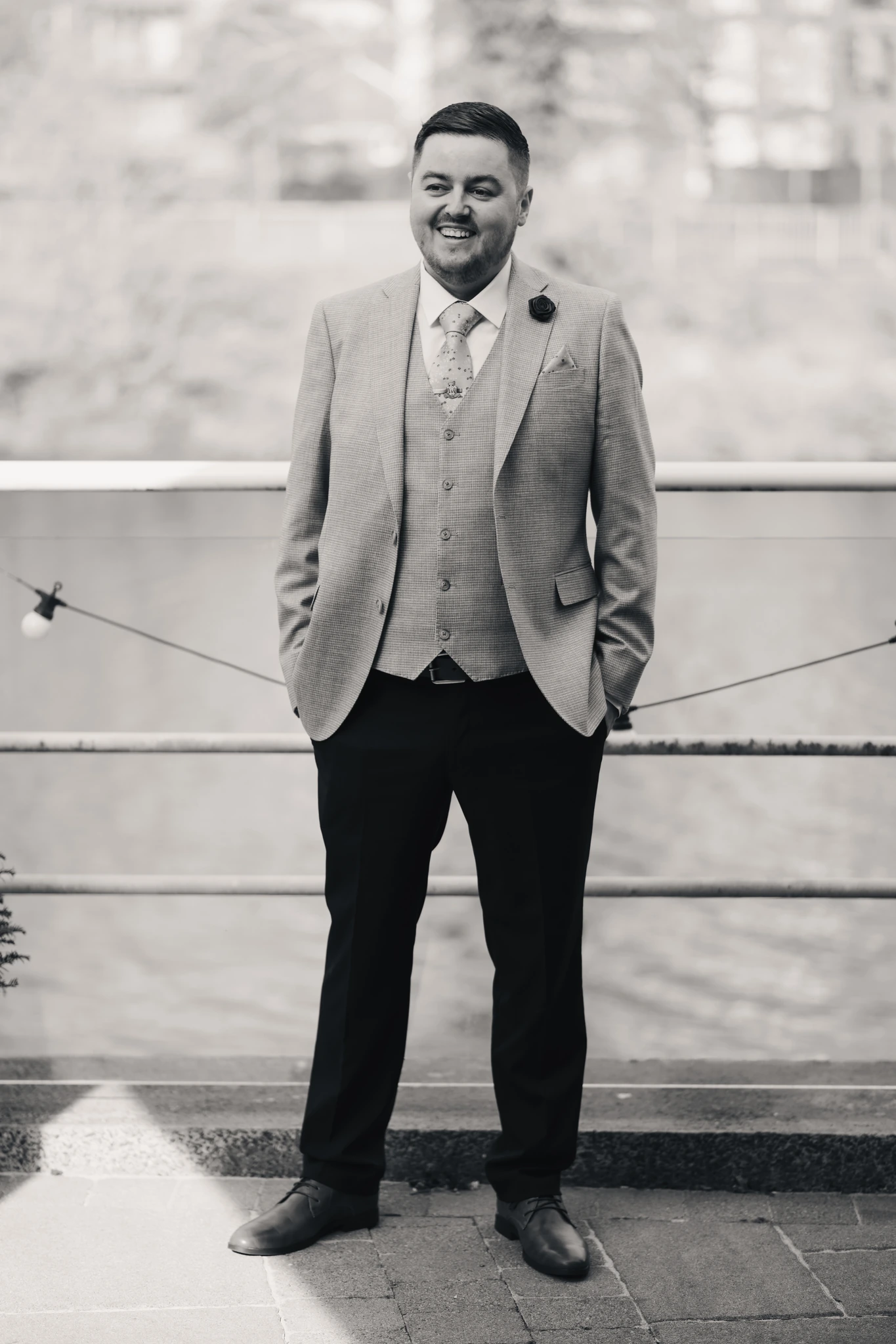 a man in a suit and tie standing next to a river