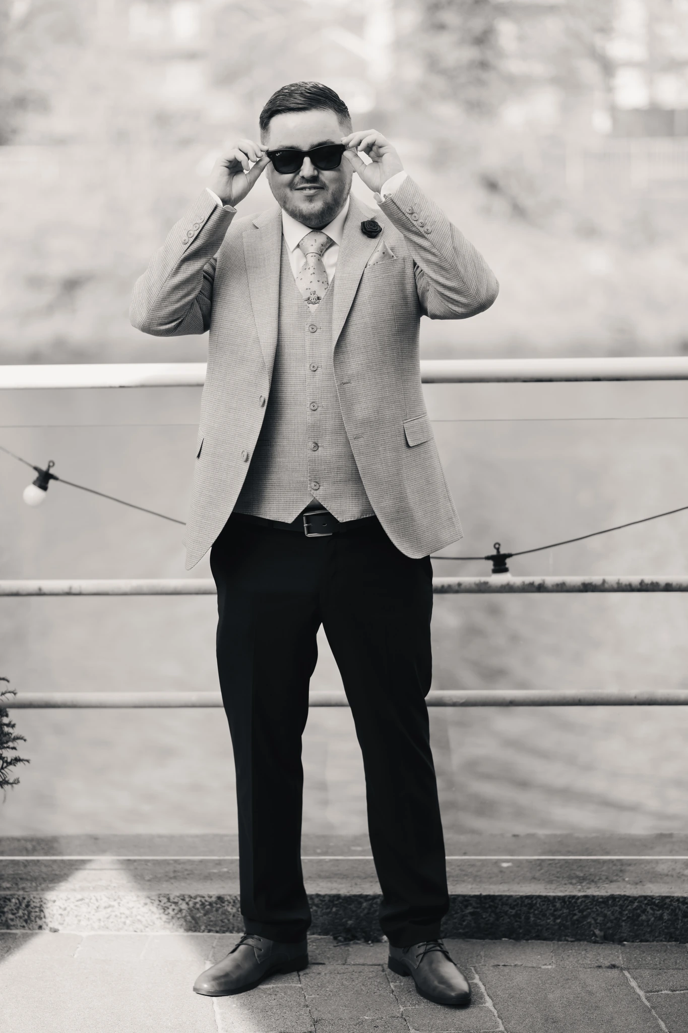 a man in a suit and tie standing next to a river