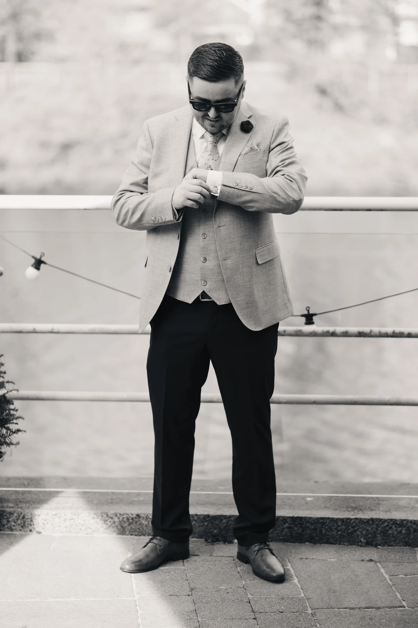 a man in a suit and tie standing next to a river