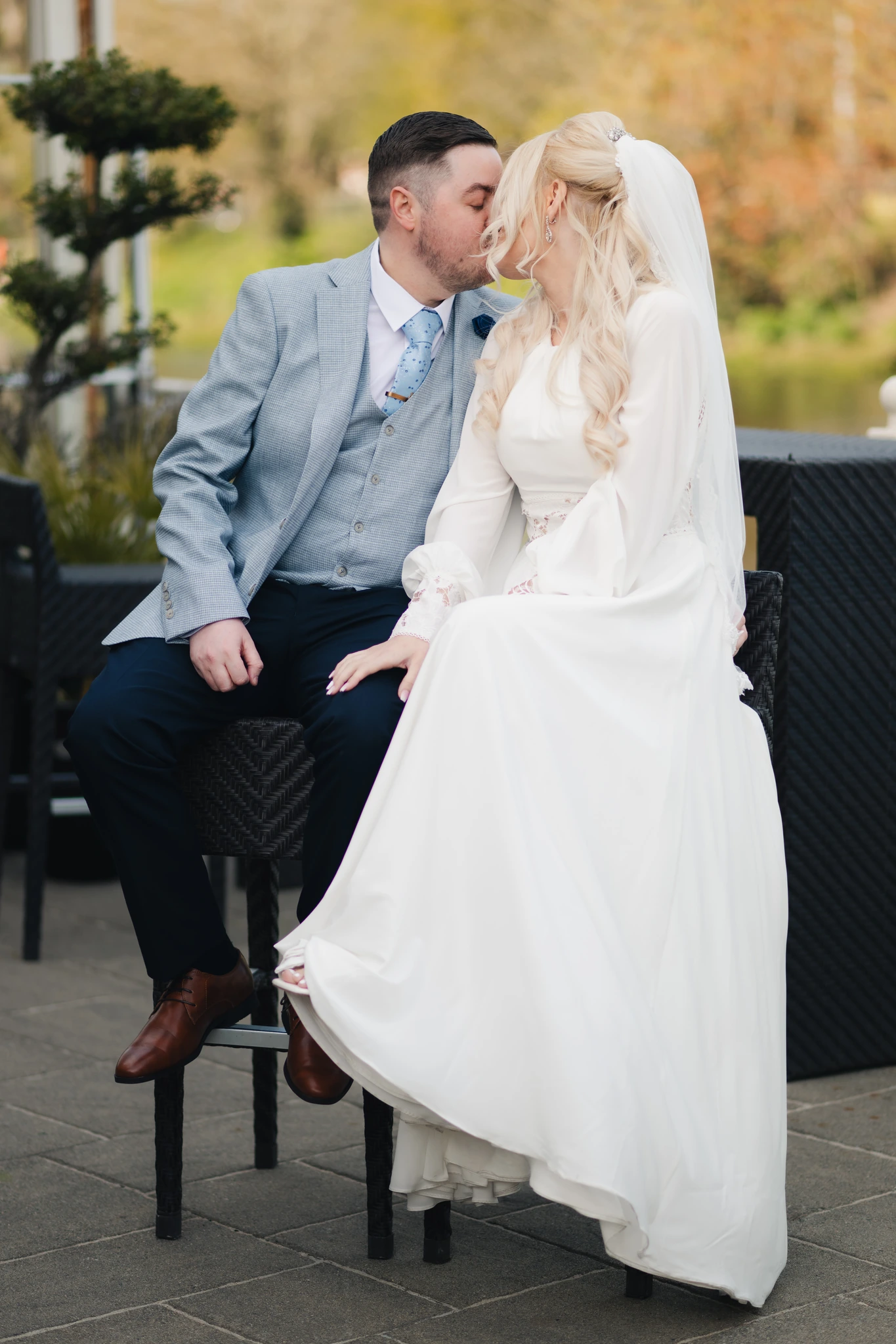 a bride and groom kiss in front of their wedding venue