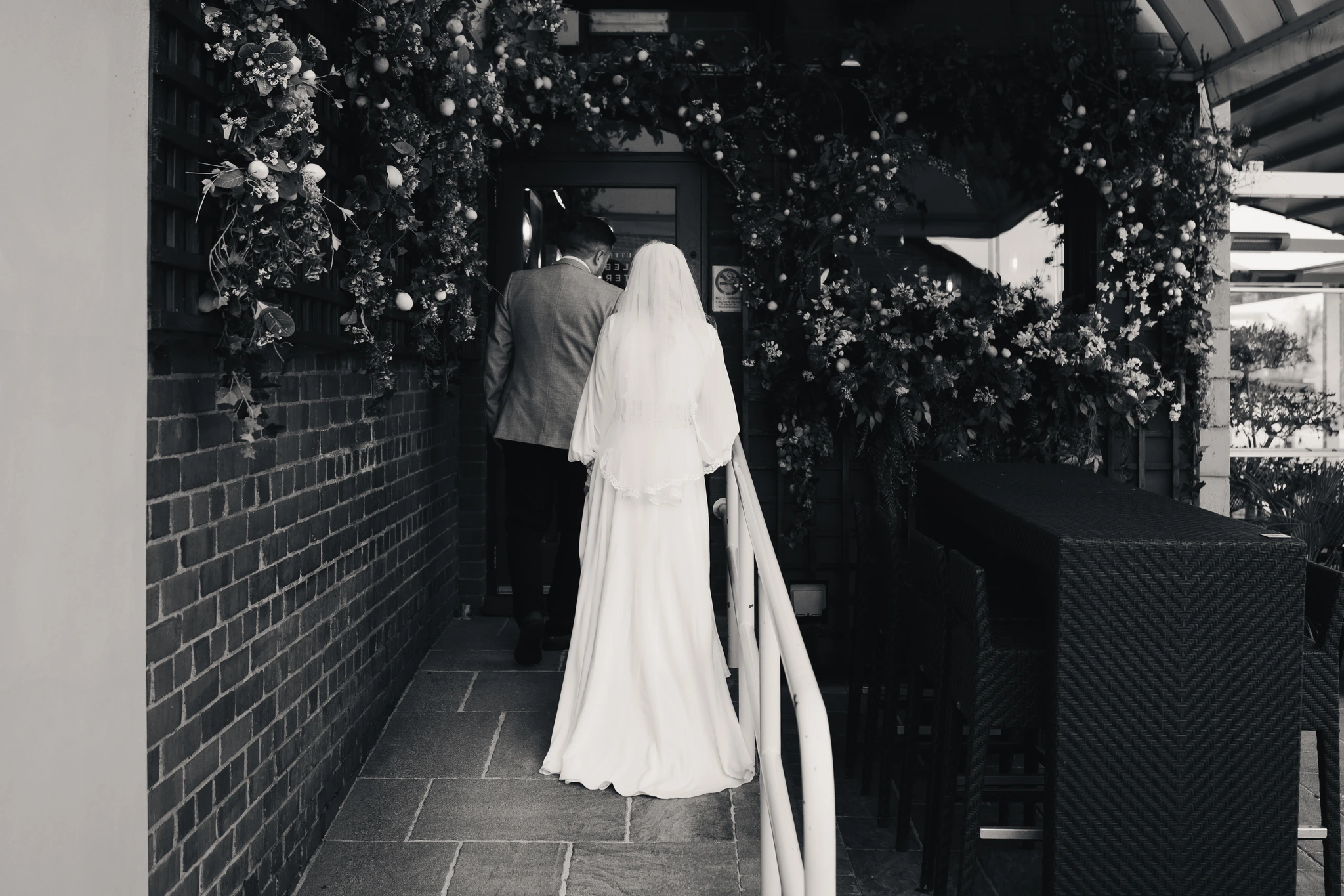 a bride and groom walking down the stairs of a restaurant