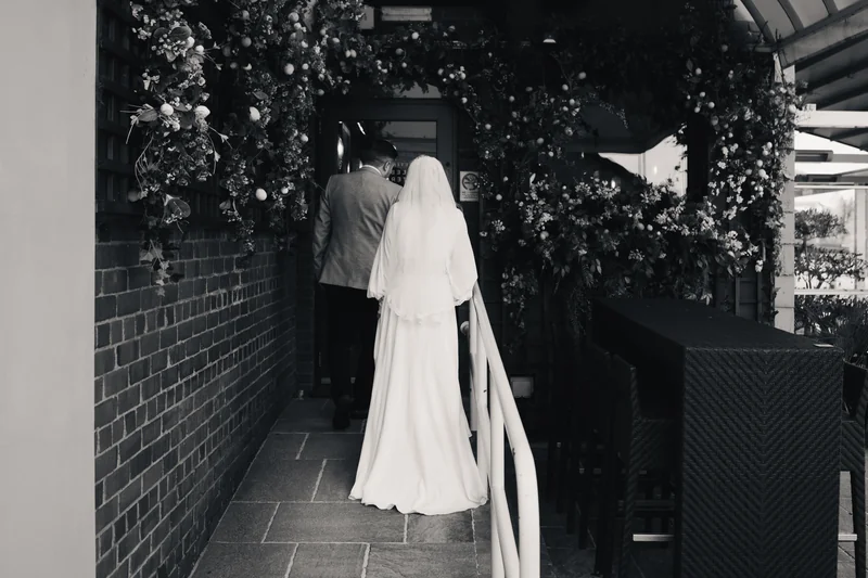 a bride and groom walking down the stairs of a restaurant