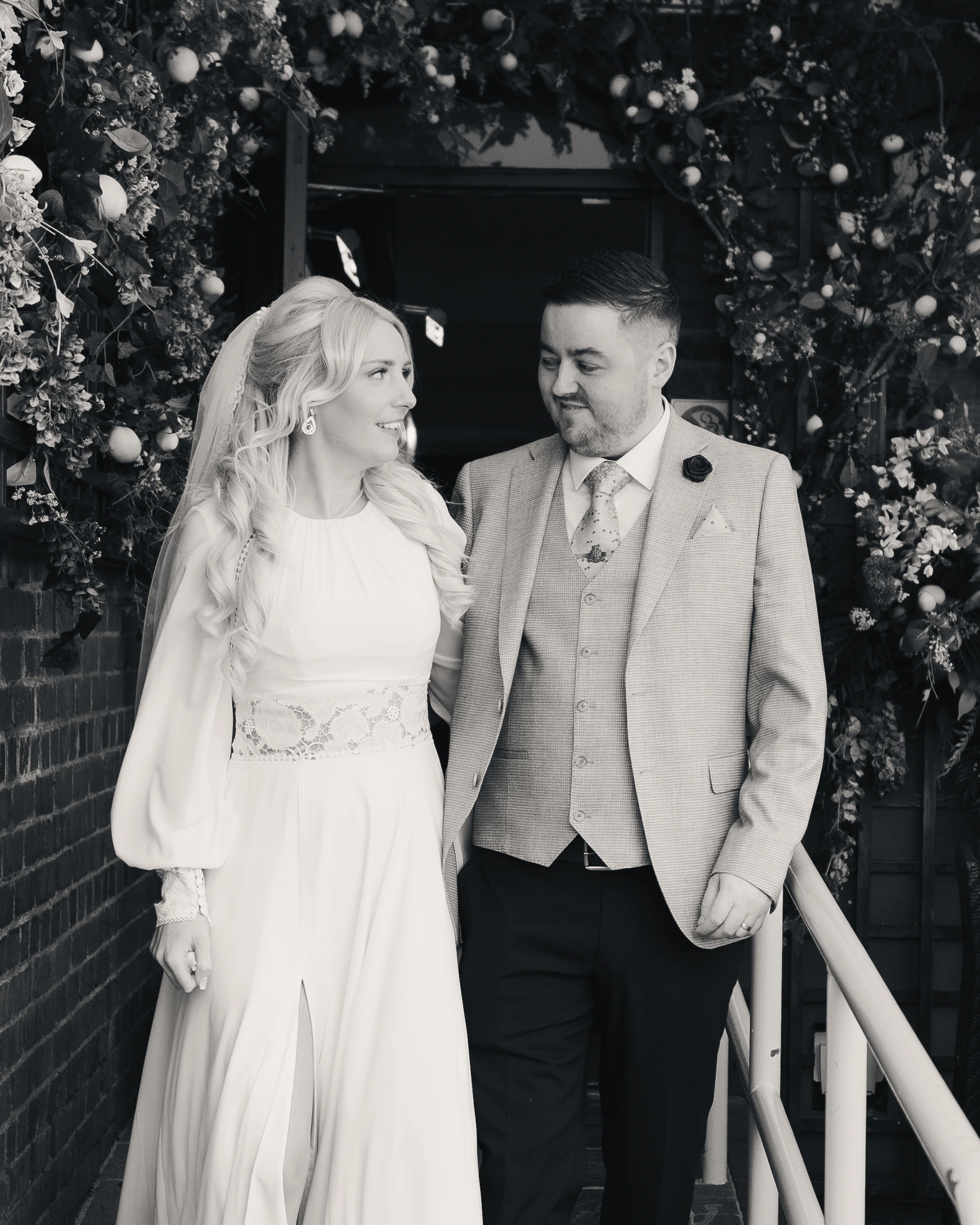 a bride and groom standing in front of a black and white photograph