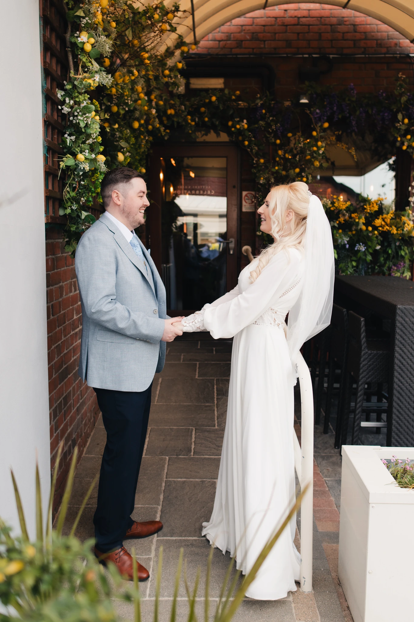 a bride and groom shake hands in front of a restaurant