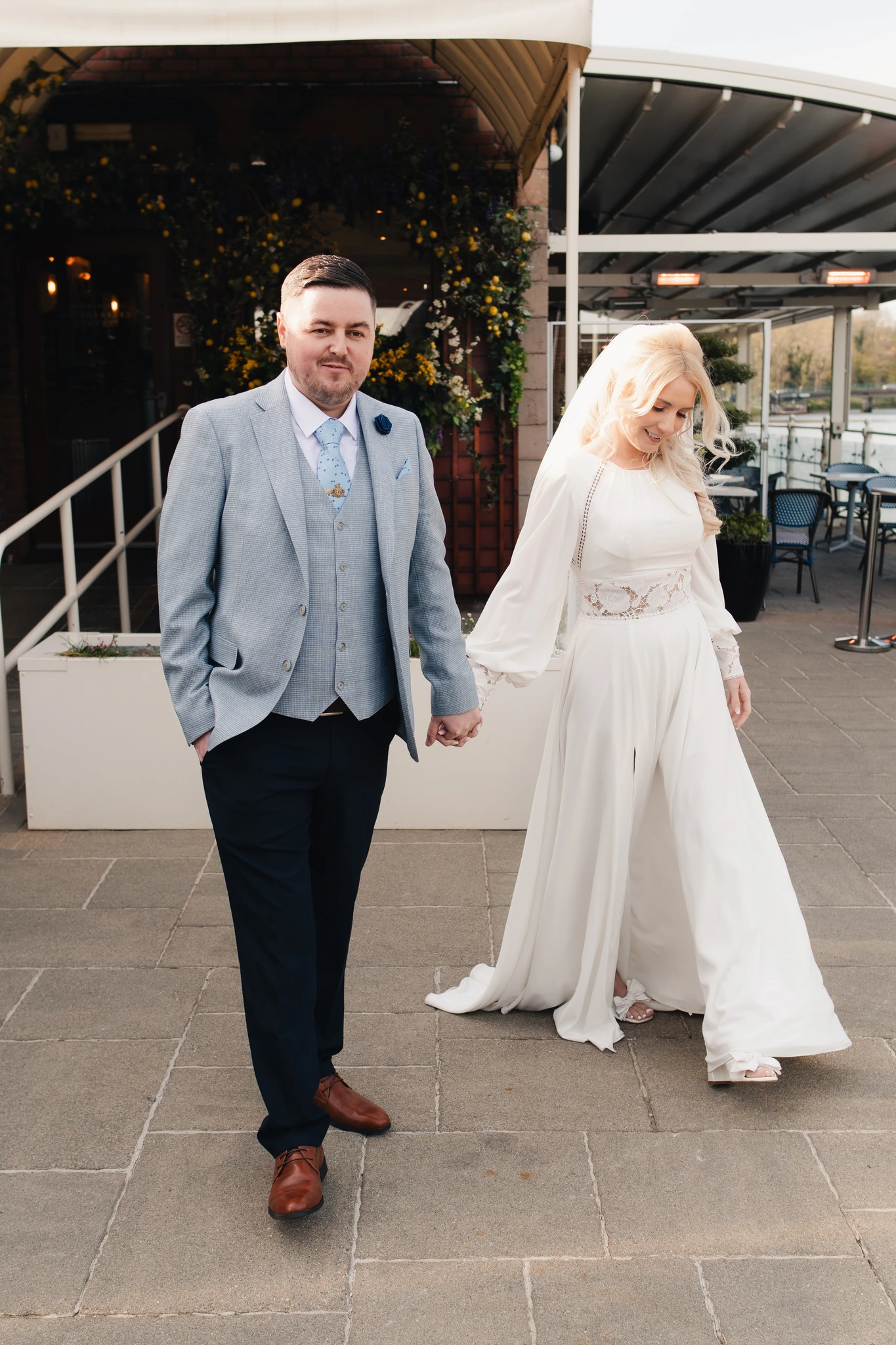 a bride and groom walk down the steps of a restaurant