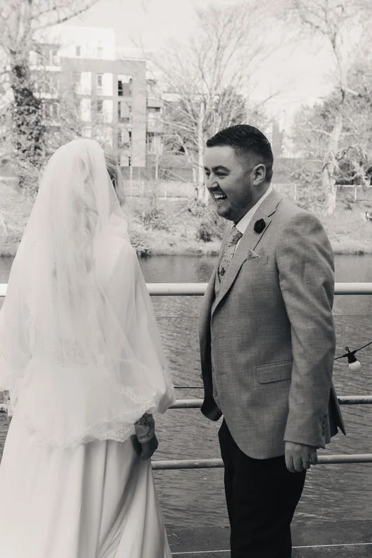a bride and groom look at each other as they walk down the aisle