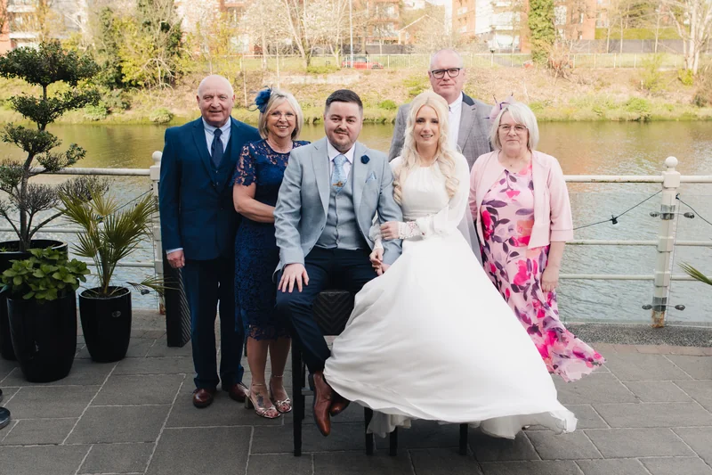 a group of family and friends posing in front of a river