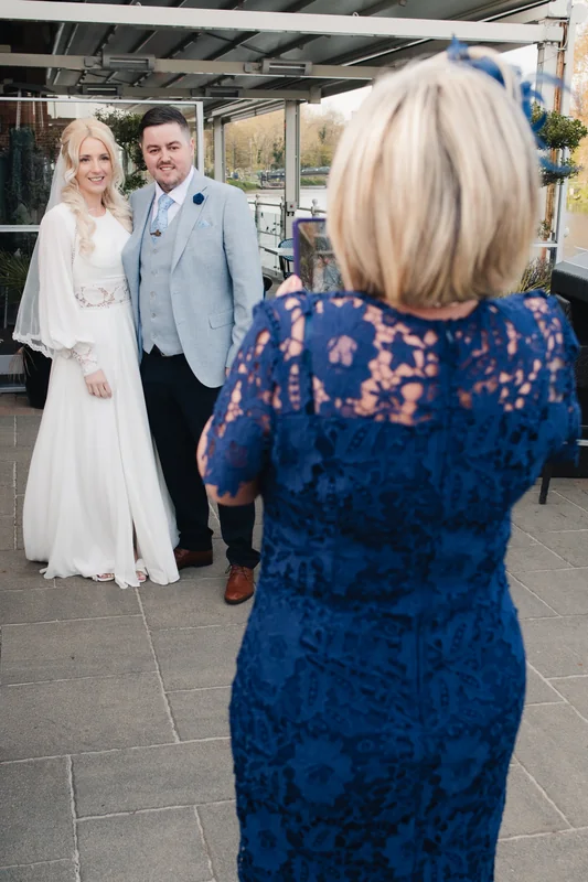 a bride and groom taking a picture in front of their wedding venue